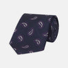 View 1 of product The Turnbull & Asser Navy and Plum Floating Paisley Silk Tie features a repeating purple and white paisley pattern, elegantly rolled up on a white background.