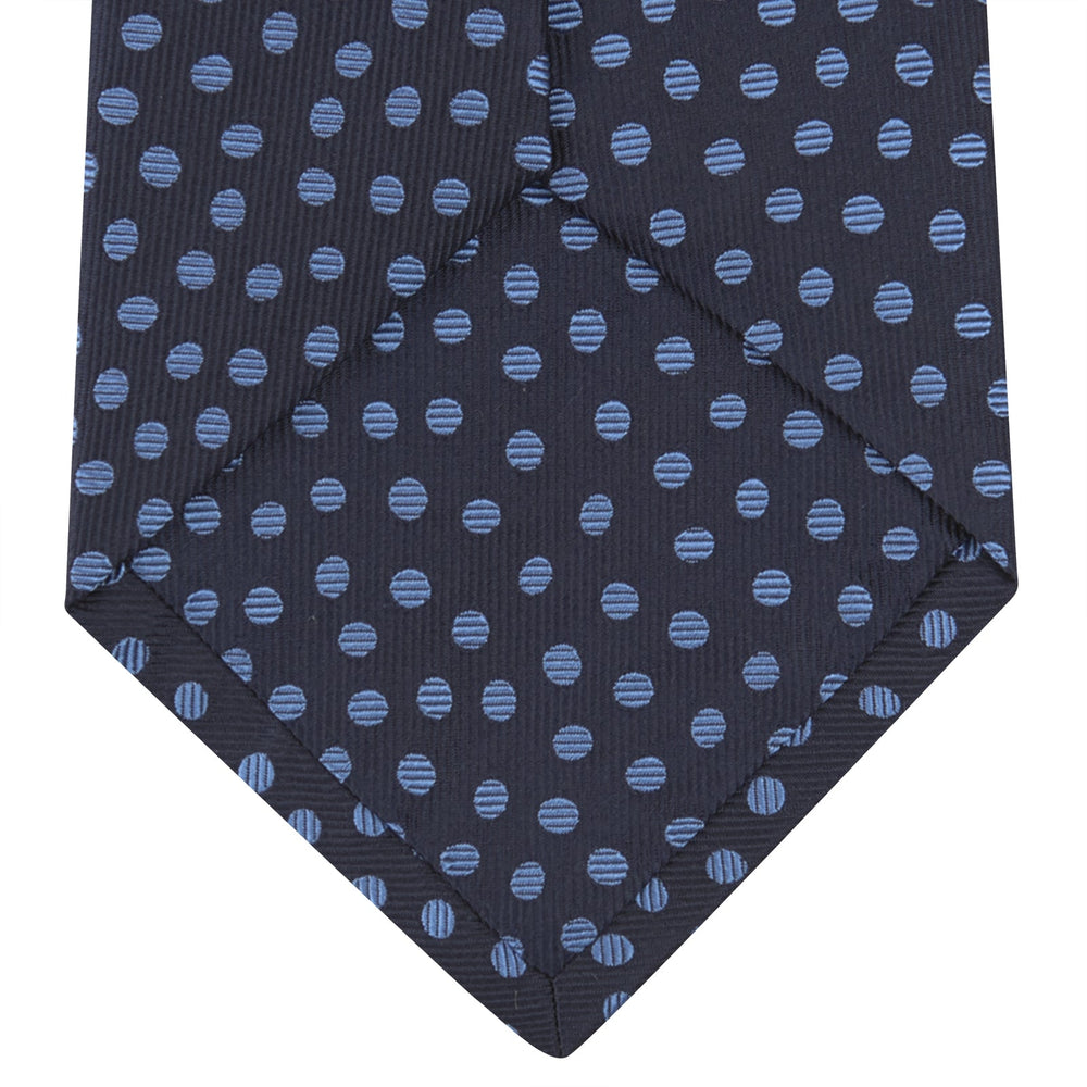 The Turnbull & Asser Navy and Blue Paint Spot Silk Tie features a classic dark navy design with evenly spaced light blue spots, ideal for office wear and shown on a plain white background.