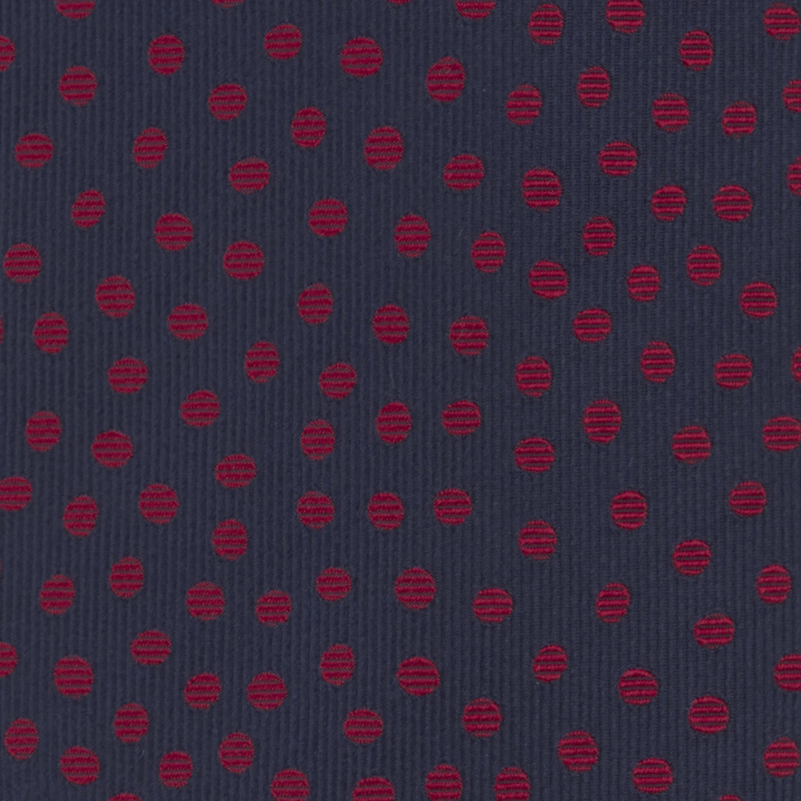 View 3 of product The Turnbull & Asser Navy and Red Paint Spot Silk Tie, featuring red spots on navy blue silk, is rolled with the wide end forward—ideal for office shirts and shown against a white background.