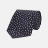 View 1 of product The Turnbull & Asser Navy and Pink Paint Spot Silk Tie, rolled at one end and set against a white background, adds a stylish touch to any office shirt with its modern spot pattern.
