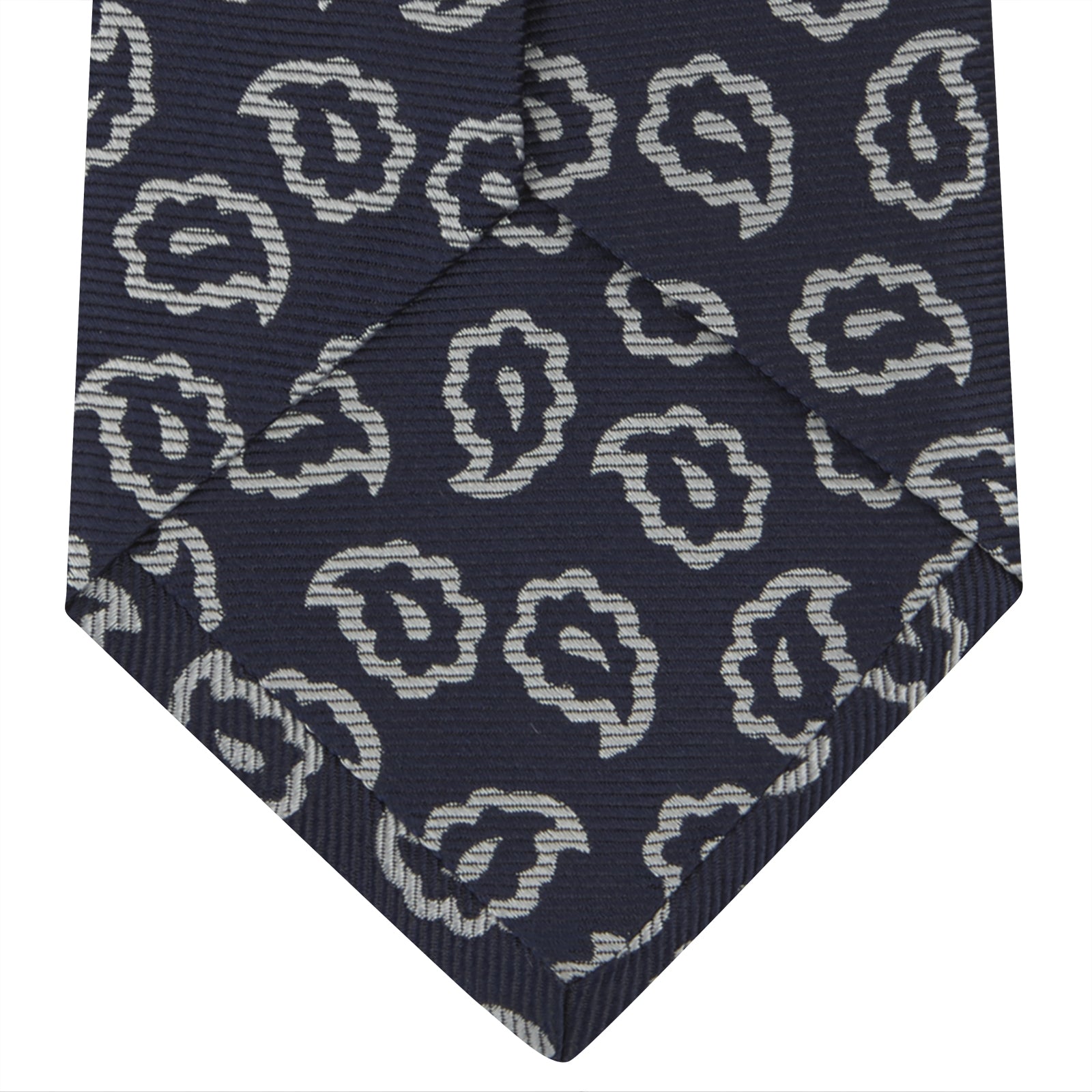 View 4 of product The Turnbull & Asser Navy and White Petal Paisley Silk Tie, featuring an elegant abstract pattern, is neatly rolled against a plain white background.