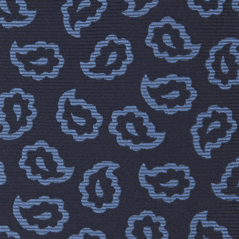 The Navy and Blue Petal Paisley Silk Tie by Turnbull & Asser features an abstract pattern of light blue paisley-like shapes, rolled up and displayed on a white background.