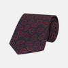 View 1 of product The Navy and Red Petal Paisley Silk Tie by Turnbull & Asser features an elegant paisley pattern on navy silk, rolled at one end and displayed on a plain white background.