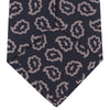 View 4 of product The Turnbull & Asser Navy and Pink Petal Paisley Silk Tie features a repeating petal paisley pattern in pink, shown rolled with the pointed end forward against a plain white background.