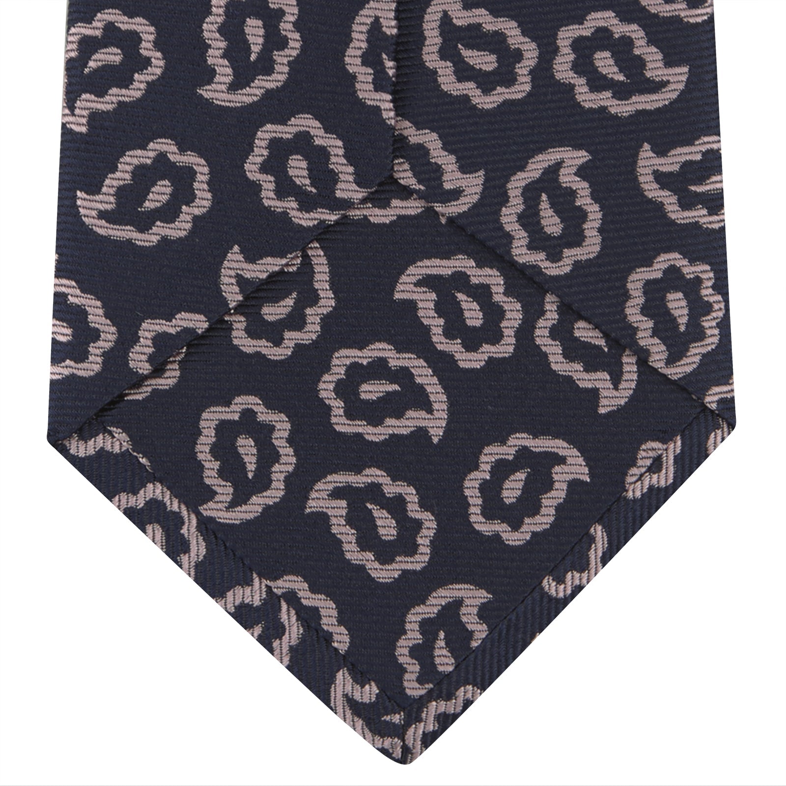 View 4 of product The Turnbull & Asser Navy and Pink Petal Paisley Silk Tie features a repeating petal paisley pattern in pink, shown rolled with the pointed end forward against a plain white background.