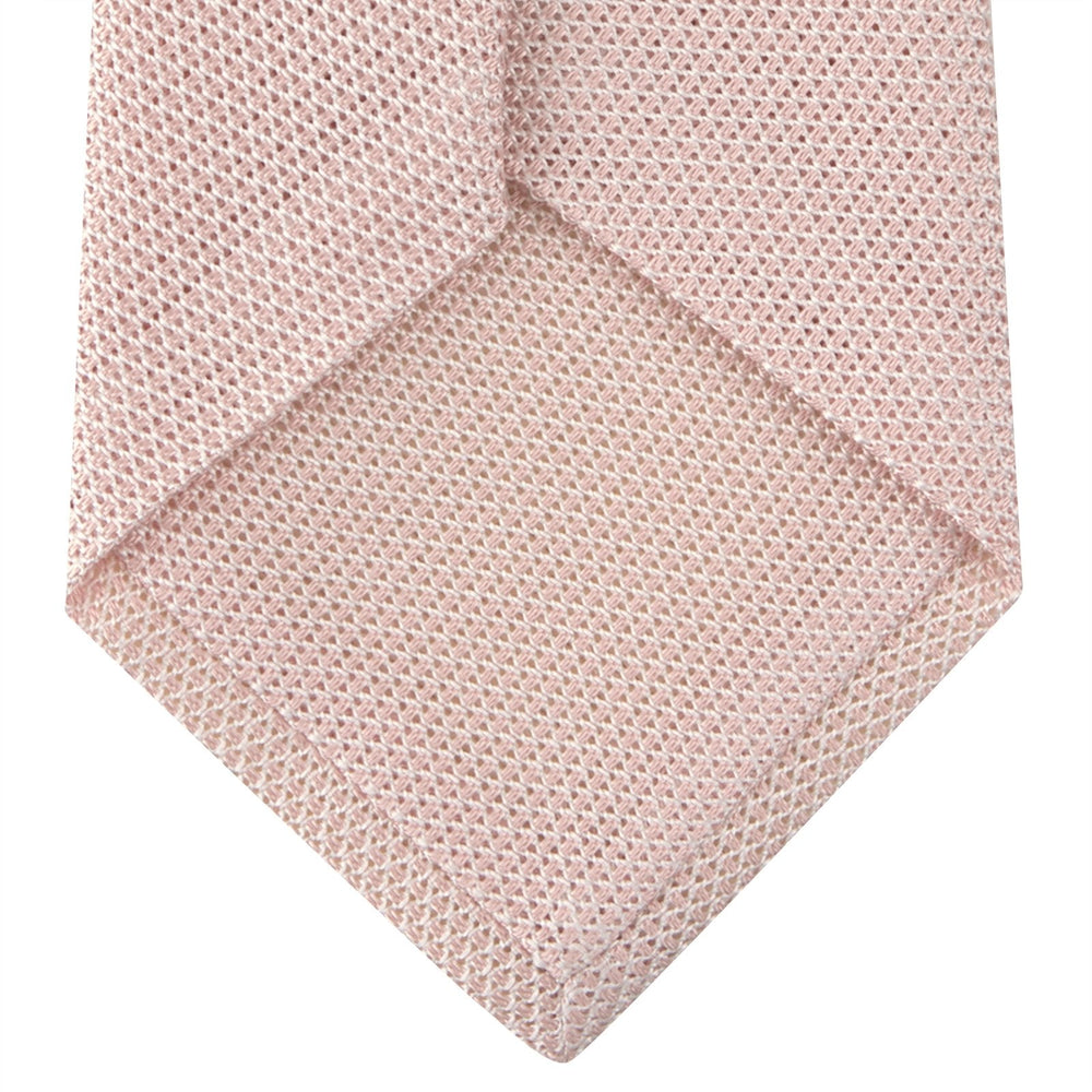 The Turnbull & Asser Light Pink Grenadine Silk Tie features a subtle woven pattern, shown rolled up on a plain white background.