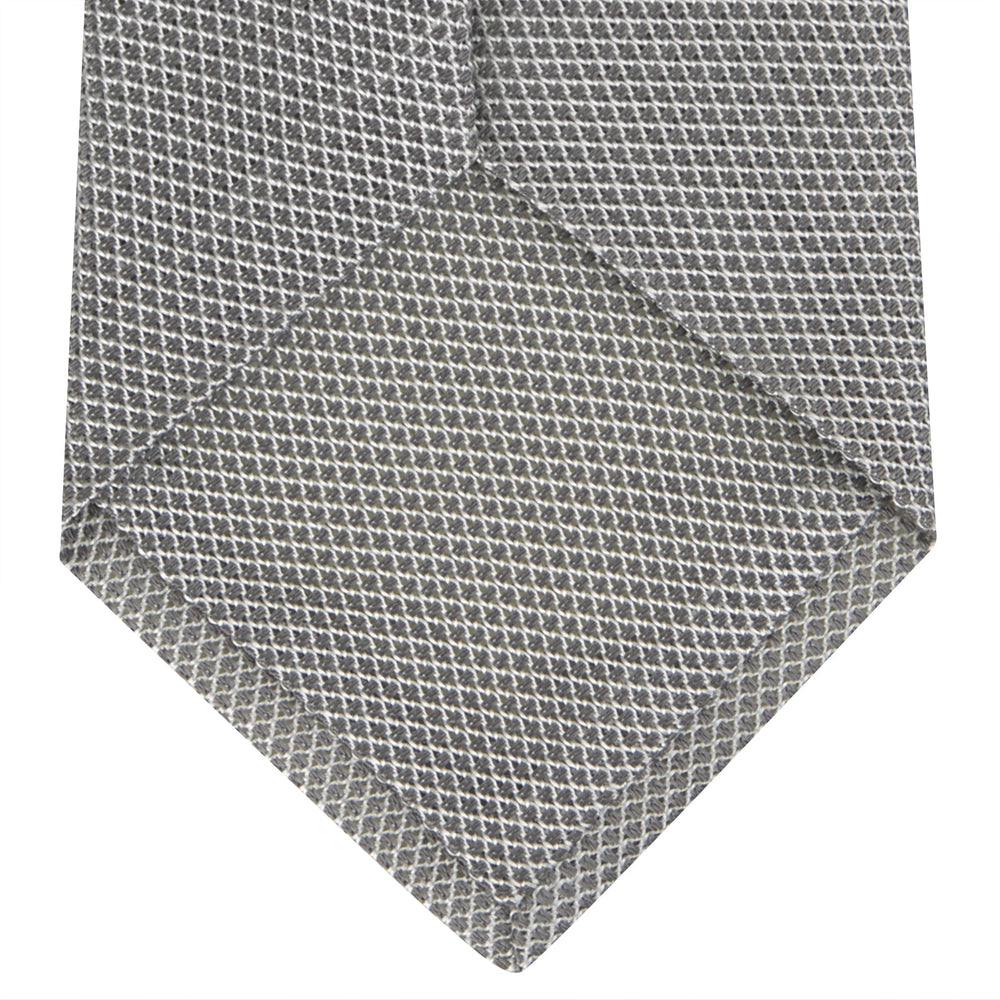 The Turnbull & Asser Light Grey Grenadine Silk Tie features a finely textured checkered pattern and superb dimensional stability, shown rolled up against a plain white background.