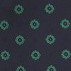 View 3 of product The Navy and Green Emblem Spot Silk Tie by Turnbull & Asser features a classic dark navy base with small green motif spots—perfect for adding a refined touch to your favorite office shirt.