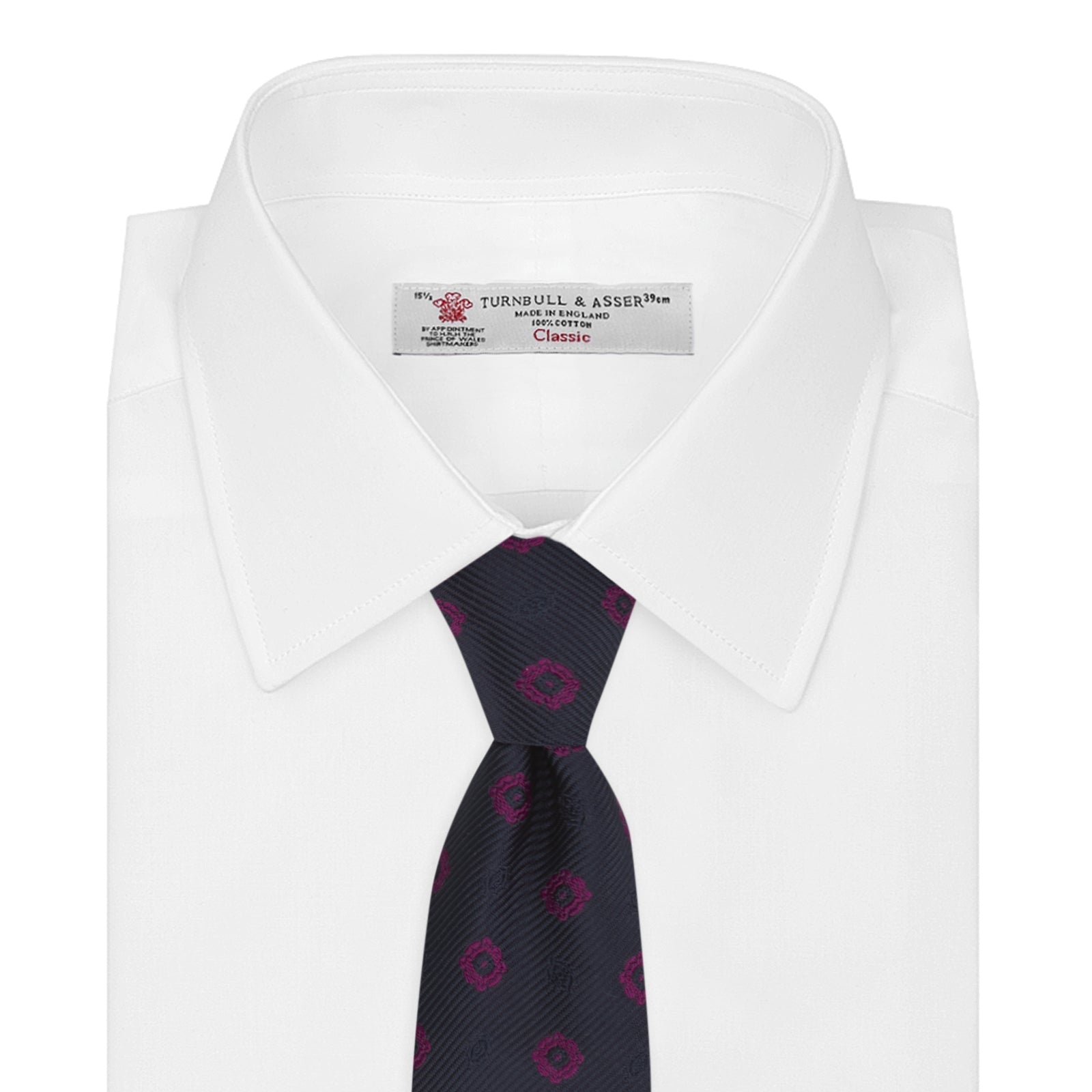 View 2 of product The Turnbull & Asser Navy and Dark Pink Emblem Spot Silk Tie features a classic pattern of small, evenly spaced emblems—ideal for complementing your favorite office shirt.