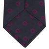 View 4 of product The Turnbull & Asser Navy and Dark Pink Emblem Spot Silk Tie features a classic pattern of small, evenly spaced emblems—ideal for complementing your favorite office shirt.
