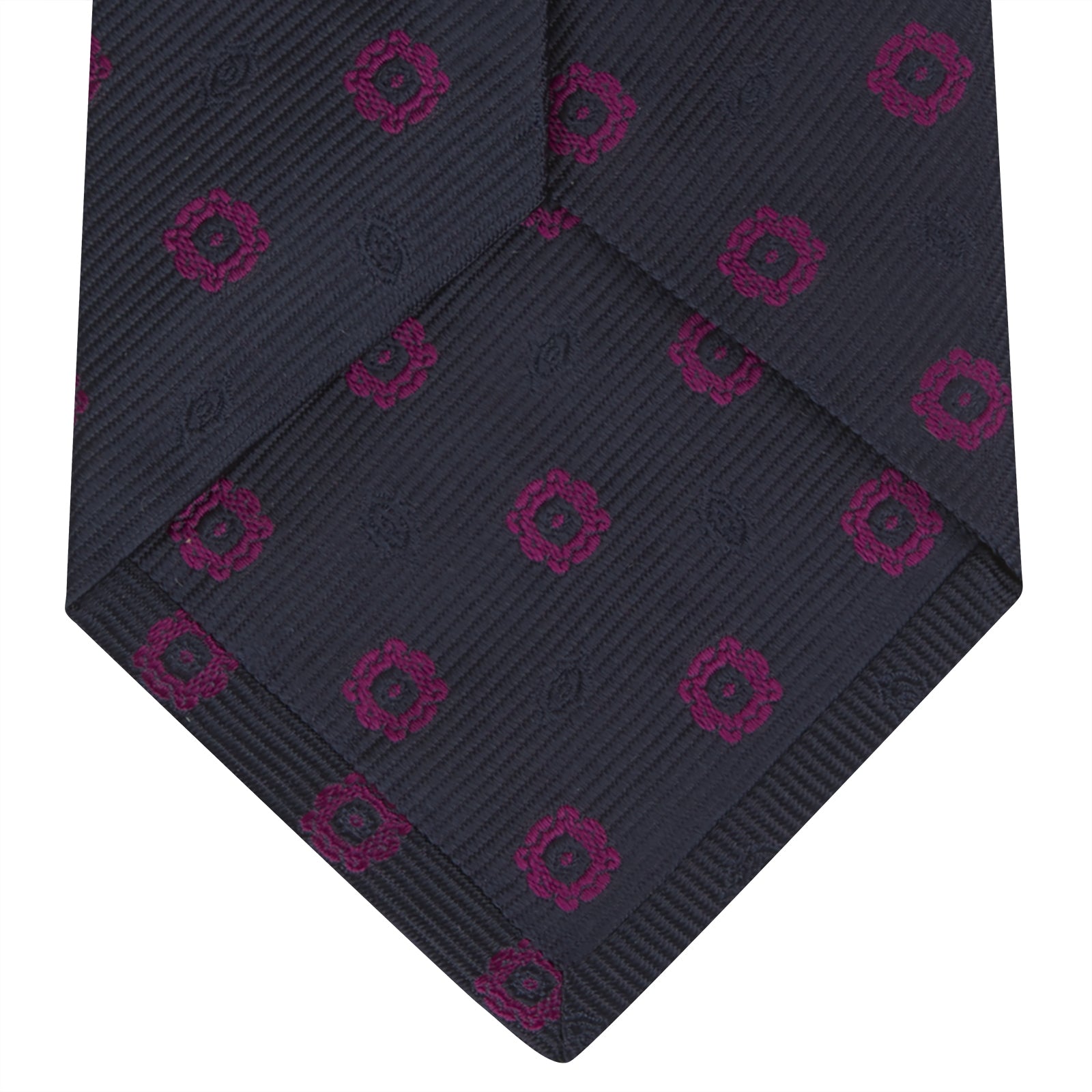 View 4 of product The Turnbull & Asser Navy and Dark Pink Emblem Spot Silk Tie features a classic pattern of small, evenly spaced emblems—ideal for complementing your favorite office shirt.