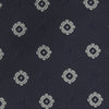 View 3 of product The Turnbull & Asser Navy and Silver Emblem Spot Silk Tie features a refined repeating emblem pattern in silver on navy silk, making it an elegant accessory for any office shirt.