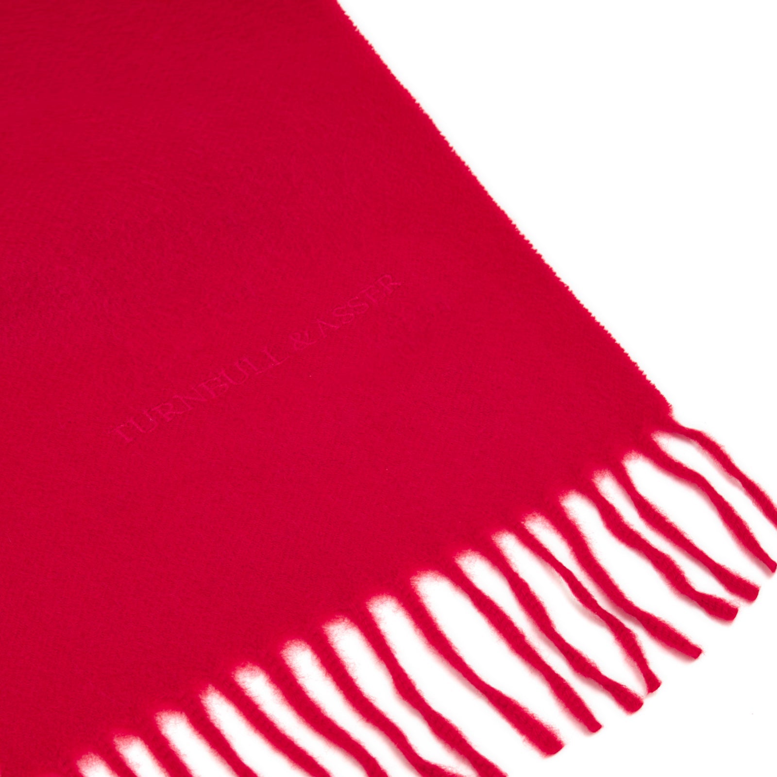 View 2 of product The Turnbull & Asser Red Pure Cashmere Scarf features hand-woven cashmere with fringed ends, elegantly folded against a plain white background for a classic Scottish look.
