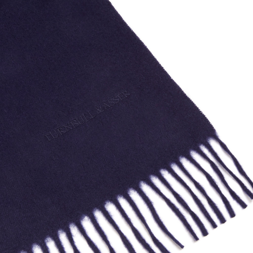 The Turnbull & Asser Navy Pure Cashmere Scarf, featuring fringed ends, is neatly folded and displayed on a plain white background—the perfect winter accessory.