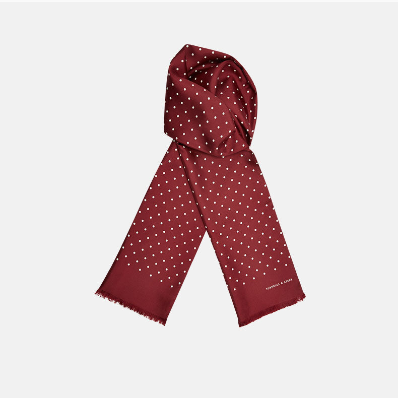 View 1 of product The Turnbull & Asser Burgundy and White Spotted Silk Scarf features small white dots, subtle fringed ends, and is neatly folded against a plain white background.