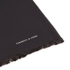 View 2 of product The Turnbull & Asser Plain Black Silk Scarf features fringed edges and subtle white branding at one end, ideal for formalwear or tuxedos, and is shown on a plain white background.