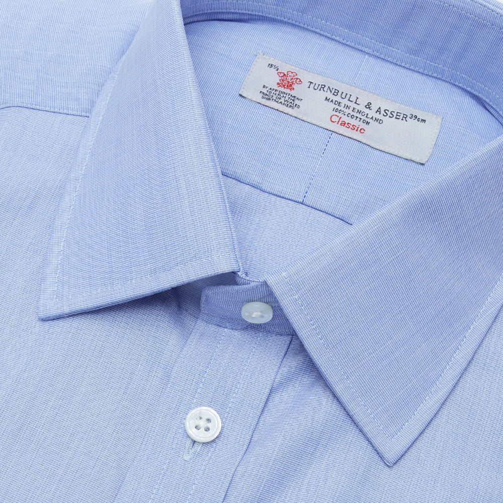 The Turnbull & Asser Blue End-on-End Cotton Shirt features a T&A collar, double cuffs, white buttons, and a chest pocket. Displayed neatly folded on a white background with the label visible at the neck—ideal for refined style.