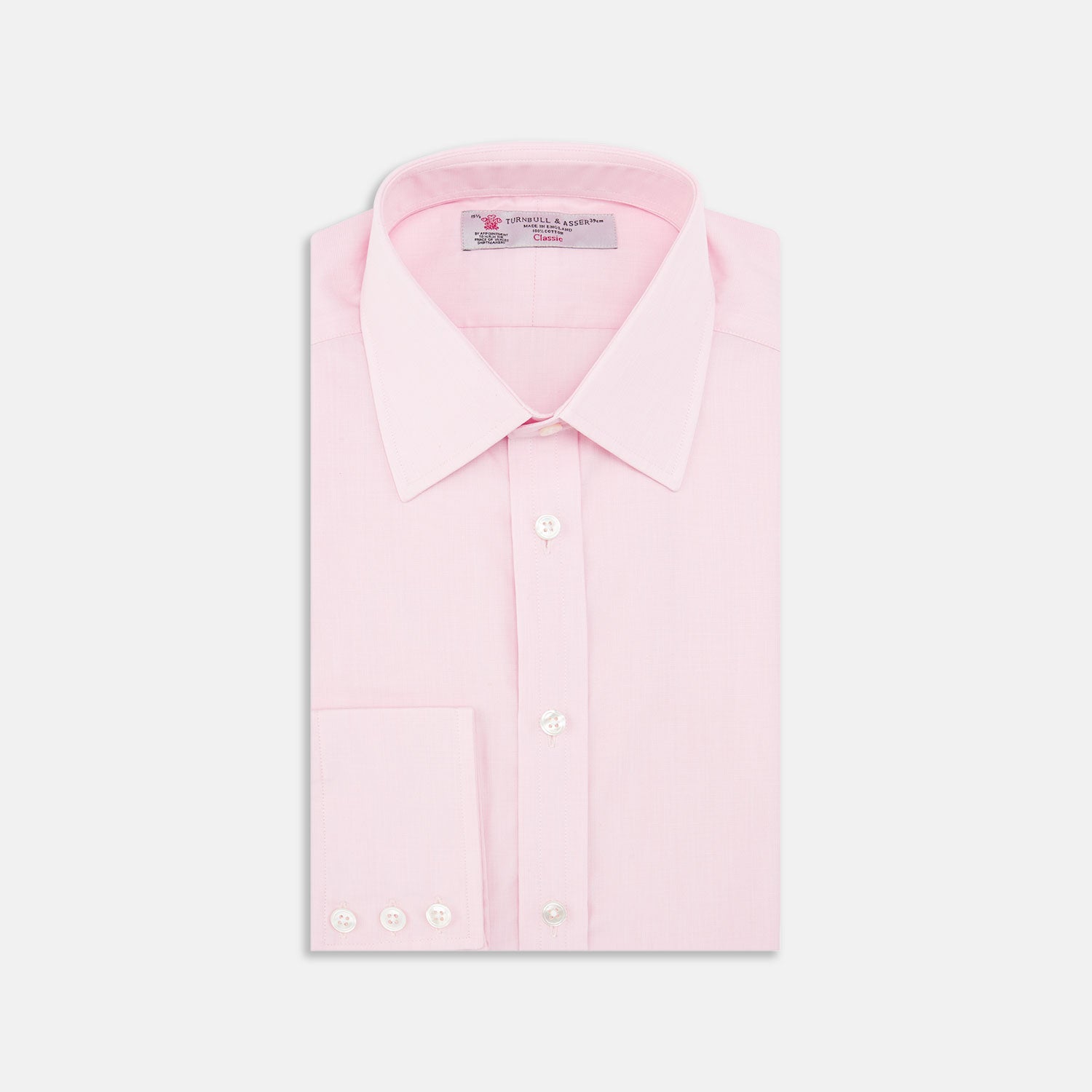 View 1 of product The Turnbull & Asser Pink End-on-End Shirt features a T&A collar, 3-button cuffs, and white buttons—a refined choice for any smart look—shown neatly folded against a plain white background.