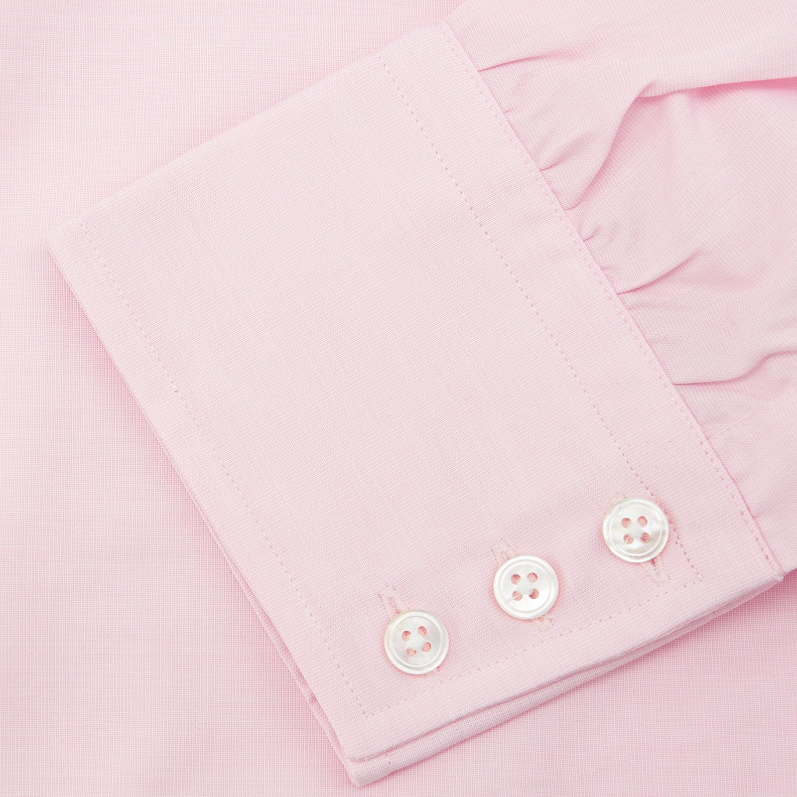View 6 of product The Turnbull & Asser Pink End-on-End Shirt features a T&A collar, 3-button cuffs, and white buttons—a refined choice for any smart look—shown neatly folded against a plain white background.