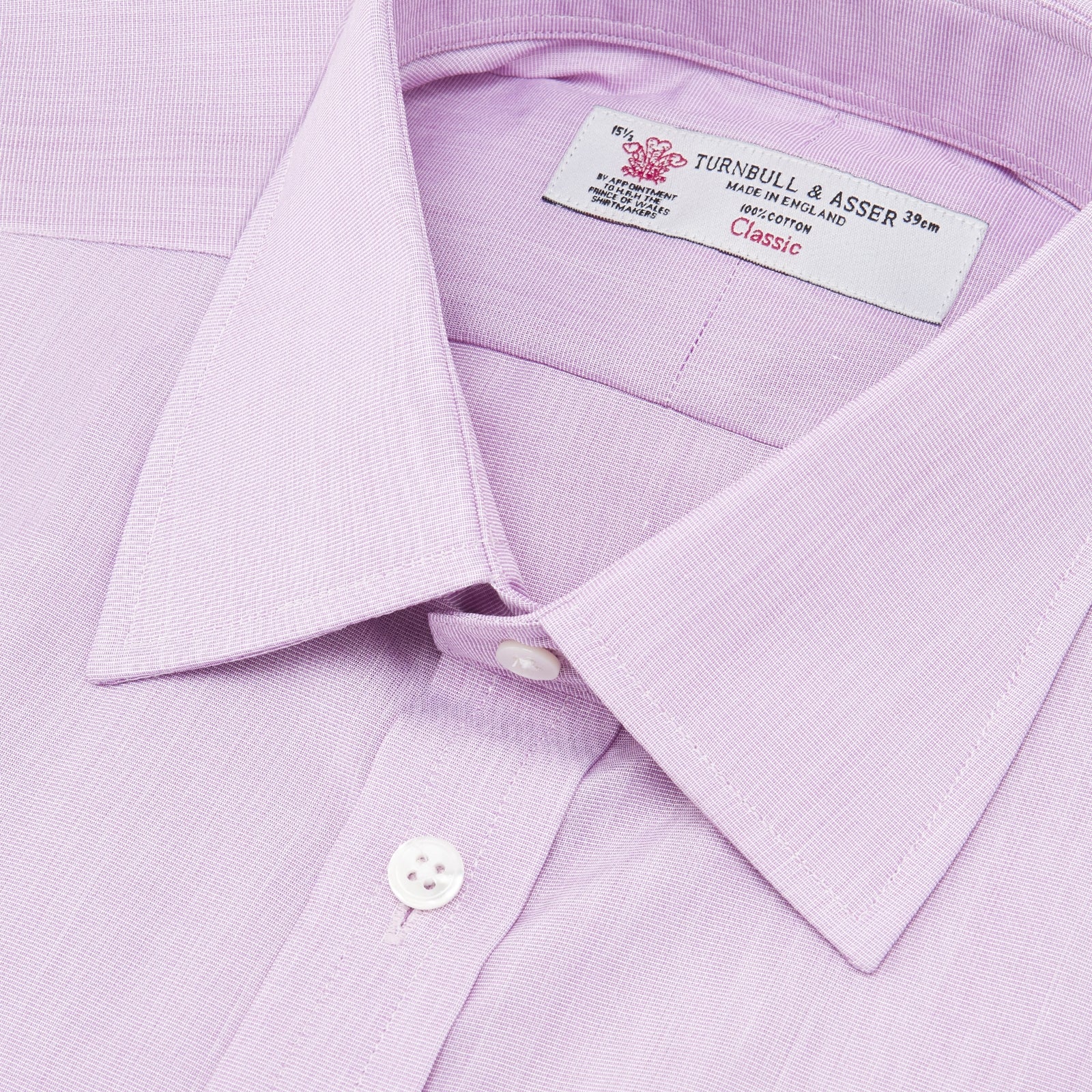 View 5 of product A neatly folded Turnbull & Asser Lilac End-on-End Shirt with T&A collar and 3-button cuffs, featuring white buttons and long sleeves, is displayed on a plain white background.