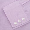 View 6 of product A neatly folded Turnbull & Asser Lilac End-on-End Shirt with T&A collar and 3-button cuffs, featuring white buttons and long sleeves, is displayed on a plain white background.