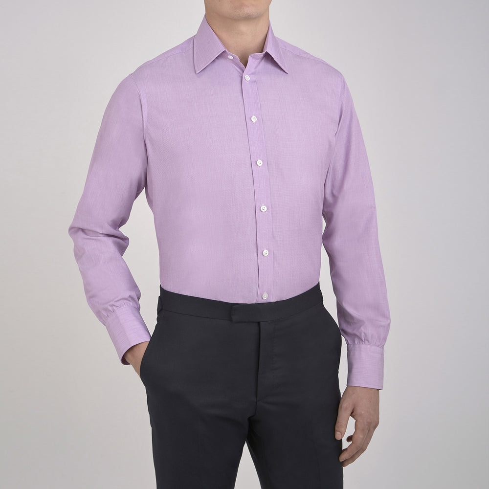 A neatly folded Turnbull & Asser Lilac End-on-End Shirt with T&A collar and 3-button cuffs, featuring white buttons and long sleeves, is displayed on a plain white background.