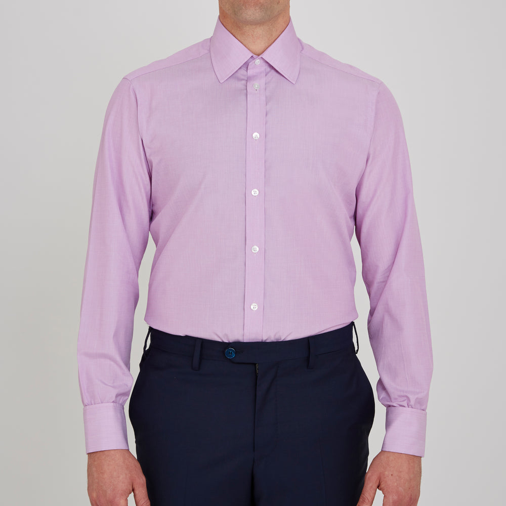 The Turnbull & Asser Lilac End-on-End Shirt features a T&A collar, double cuffs, and white buttons. Crafted from Italian two-tone cloth, this long-sleeved shirt is neatly folded and displayed on a plain white background.