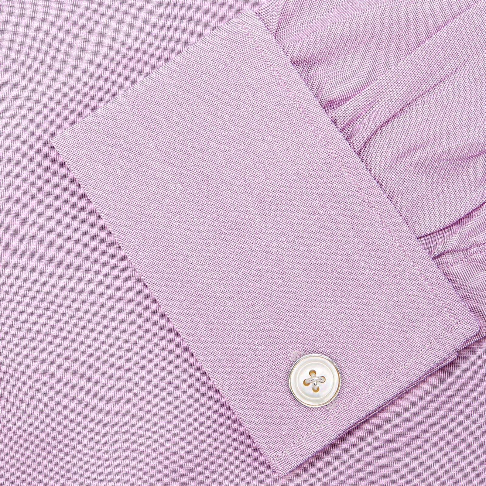 View 6 of product The Turnbull & Asser Lilac End-on-End Shirt features a T&A collar, double cuffs, and white buttons. Crafted from Italian two-tone cloth, this long-sleeved shirt is neatly folded and displayed on a plain white background.