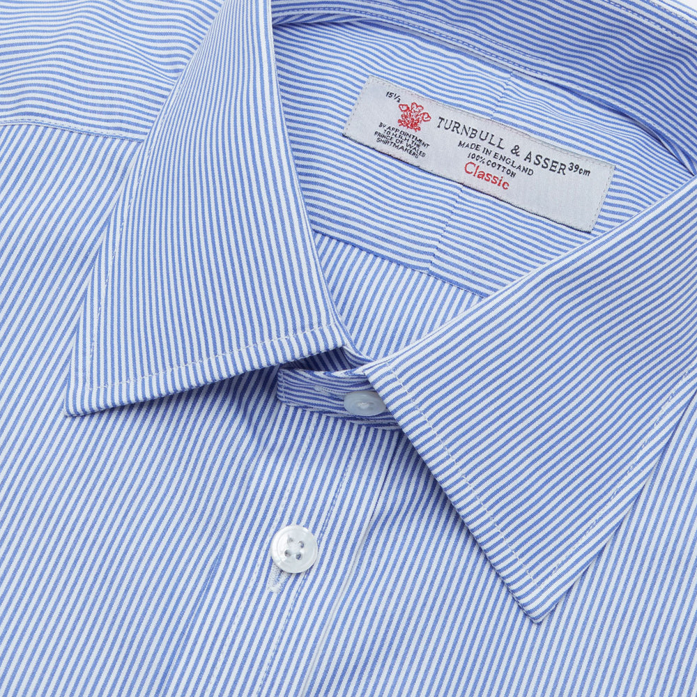 The Turnbull & Asser Blue Fine Bengal Stripe Shirt features a classic T&A collar, white buttons, and 3-button cuffs, displayed neatly folded against a plain white background.