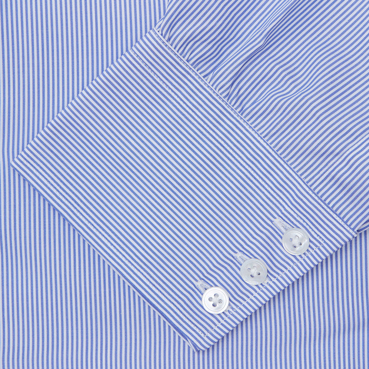 View 6 of product The Turnbull & Asser Blue Fine Bengal Stripe Shirt features a classic T&A collar, white buttons, and 3-button cuffs, displayed neatly folded against a plain white background.
