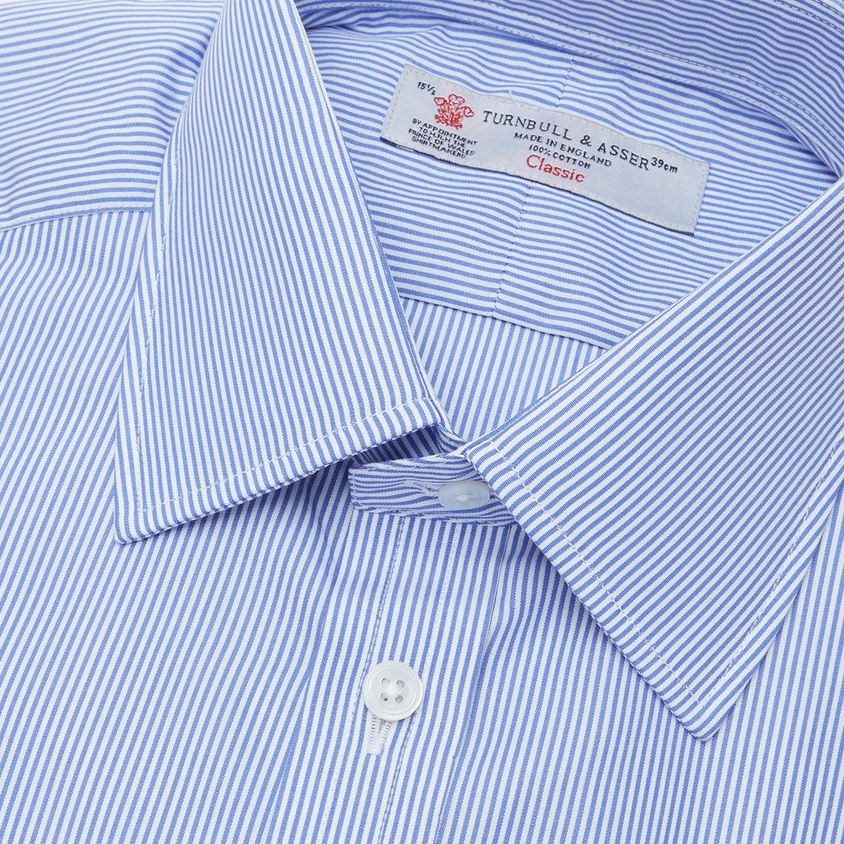 View 5 of product The Turnbull & Asser Blue Fine Bengal Stripe Shirt features a T&A collar, double cuffs, and white buttons, neatly folded and displayed against a plain white background.