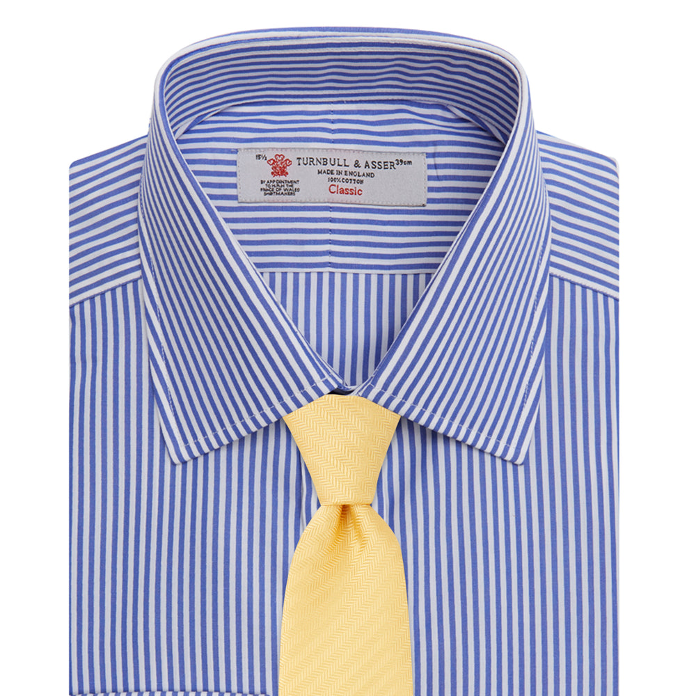 The Turnbull & Asser Blue Bengal Stripe Shirt features a T&A collar, double cuffs, and crisp white buttons. Made from cotton with blue and white bengal stripes, it’s neatly folded and displayed on a white background.