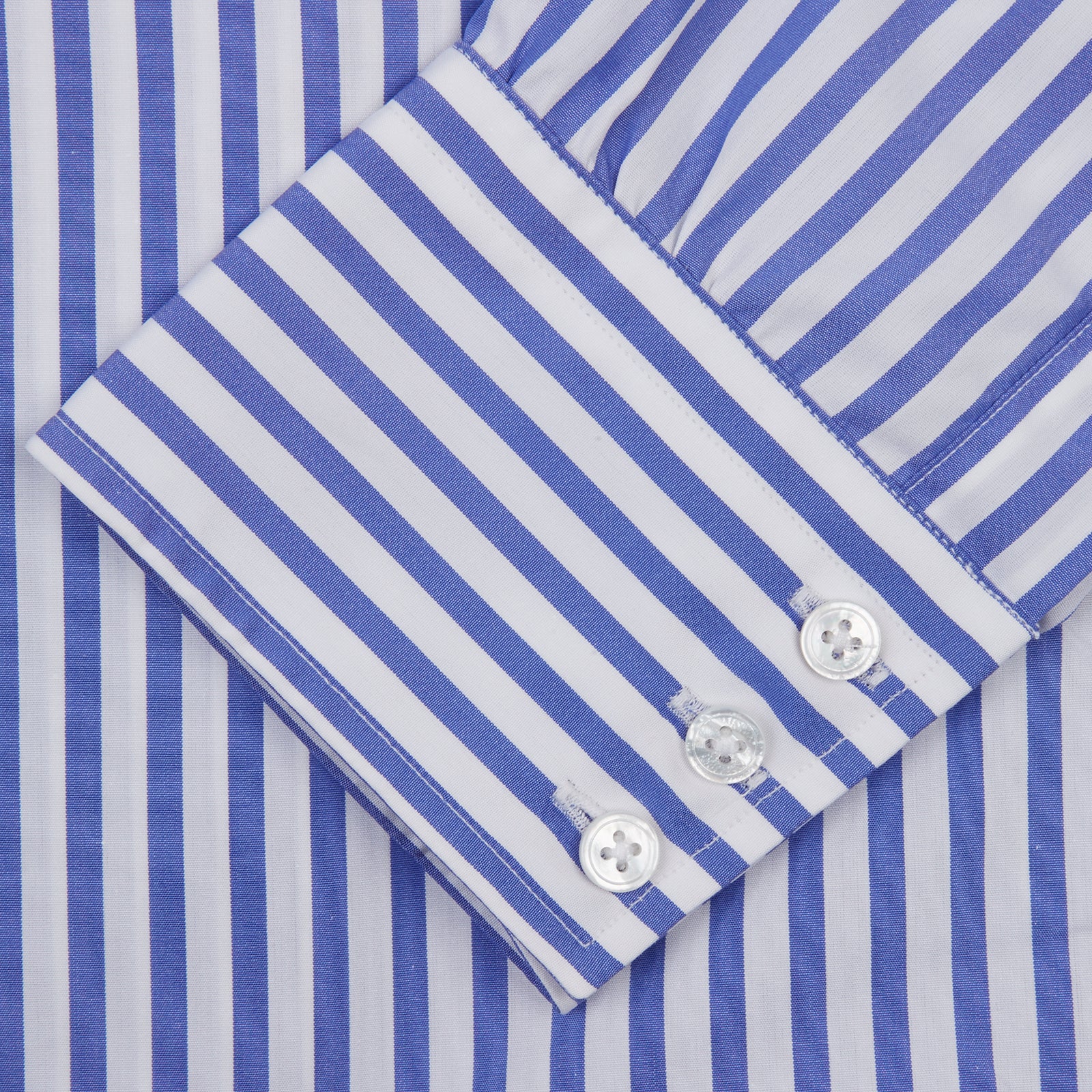 View 5 of product The Turnbull & Asser Blue and White Candy Stripe Shirt features a T&A collar, 3-button cuffs, and crisp white buttons, displayed neatly folded against a white background for a classic look.