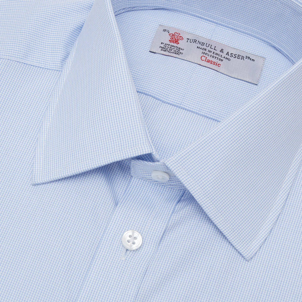The Turnbull & Asser Light Blue Fine Check Shirt for men features a T&A collar, 3-button cuffs, classic white buttons, and a refined check design with a visible label inside the collar.