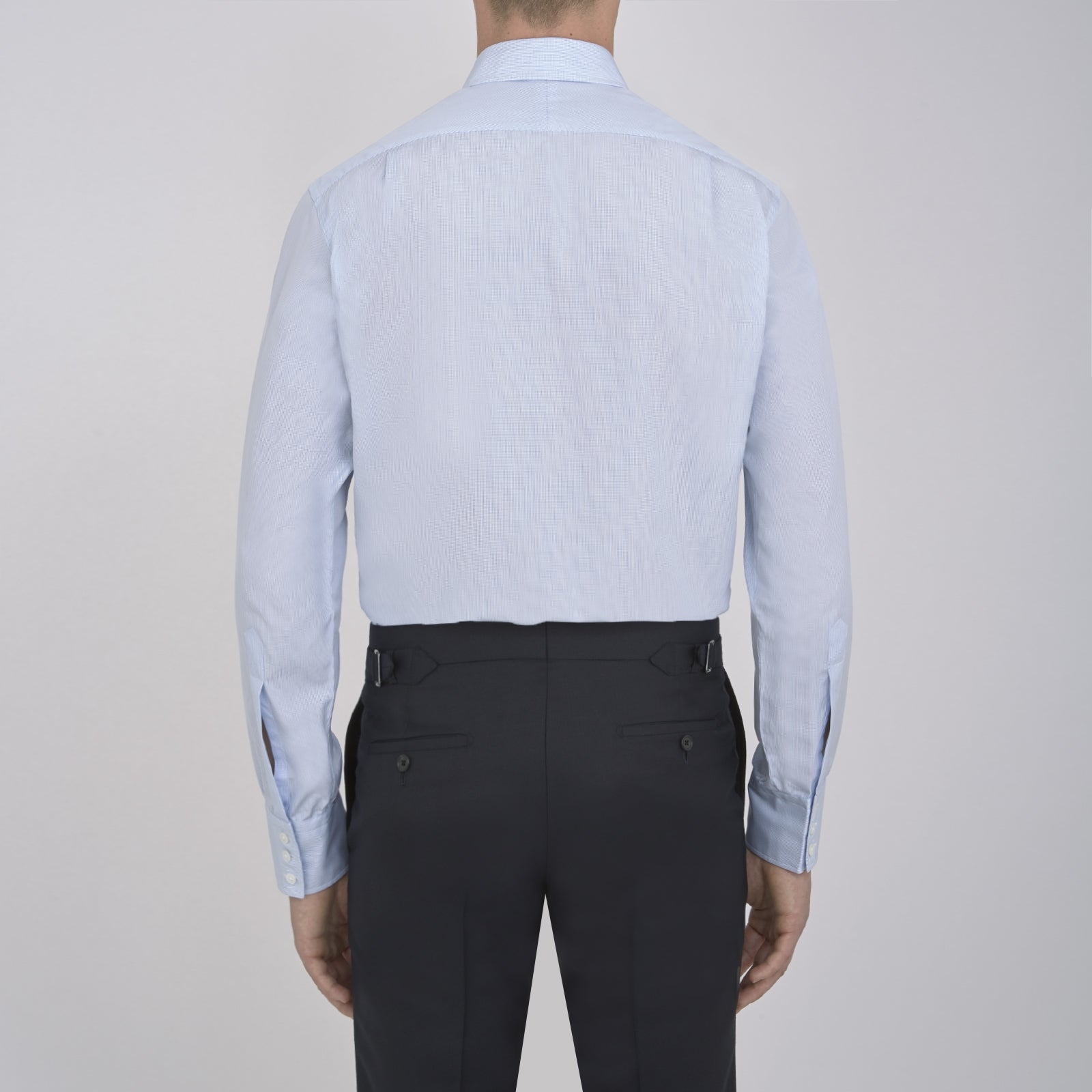 View 3 of product The Turnbull & Asser Light Blue Fine Check Shirt for men features a T&A collar, 3-button cuffs, classic white buttons, and a refined check design with a visible label inside the collar.