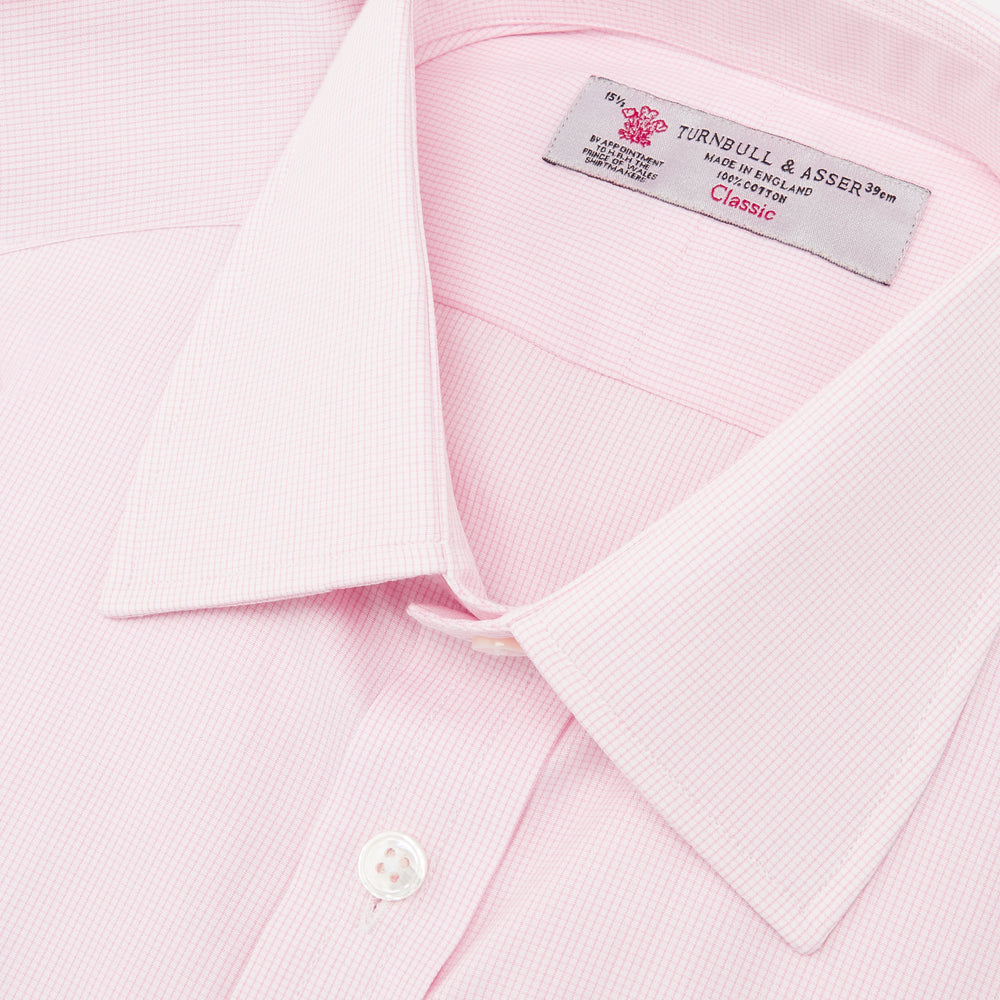 The Turnbull & Asser Pink Fine Check Shirt features a T&A collar, 3-button cuffs, and a subtle pink check design, made from fine cotton. Displayed neatly folded against a plain backdrop.