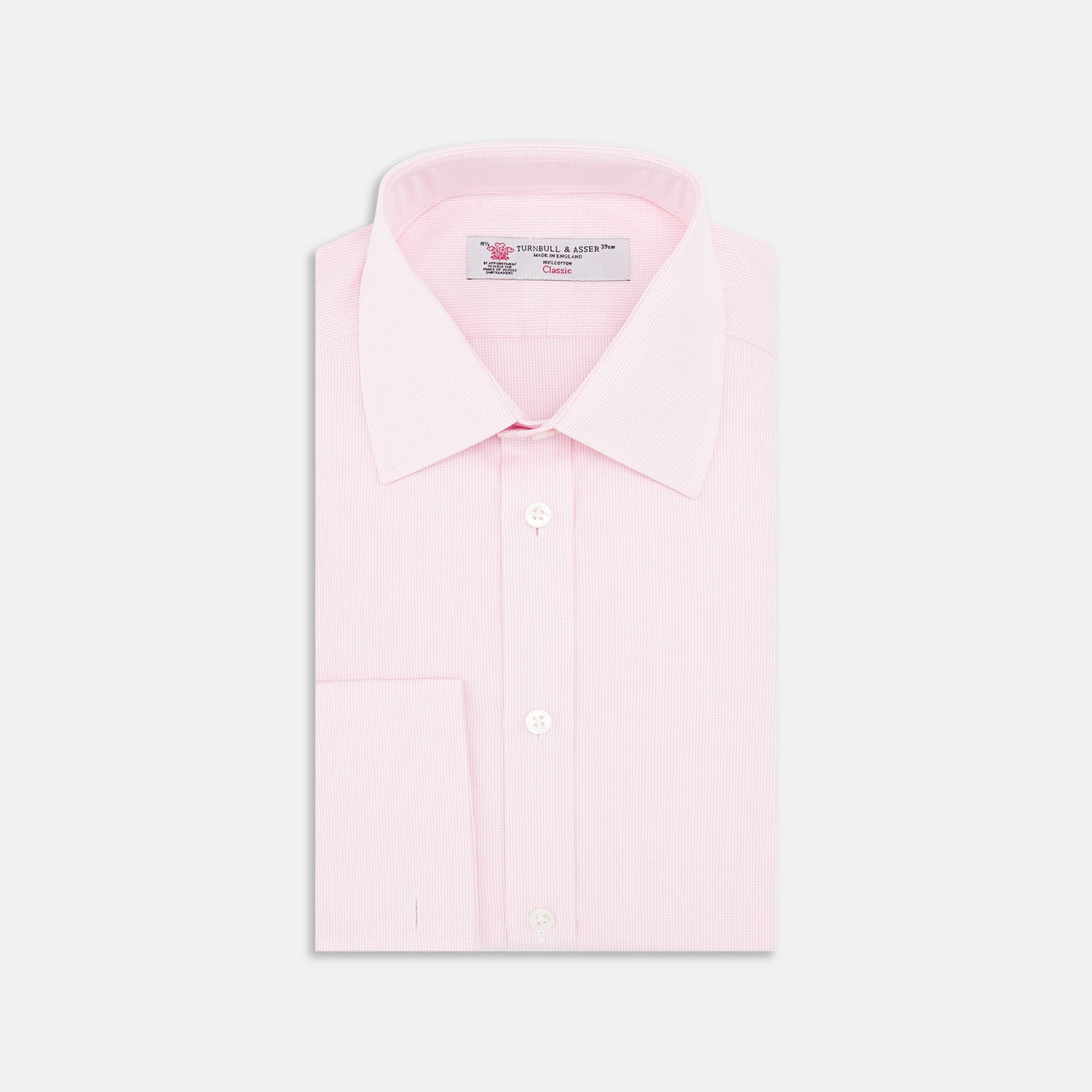 View 1 of product The Turnbull & Asser Pink Fine Check Shirt features a T&A collar, double cuffs, and classic white buttons, neatly folded and displayed against a plain white background.