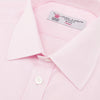 View 5 of product The Turnbull & Asser Pink Fine Check Shirt features a T&A collar, double cuffs, and classic white buttons, neatly folded and displayed against a plain white background.