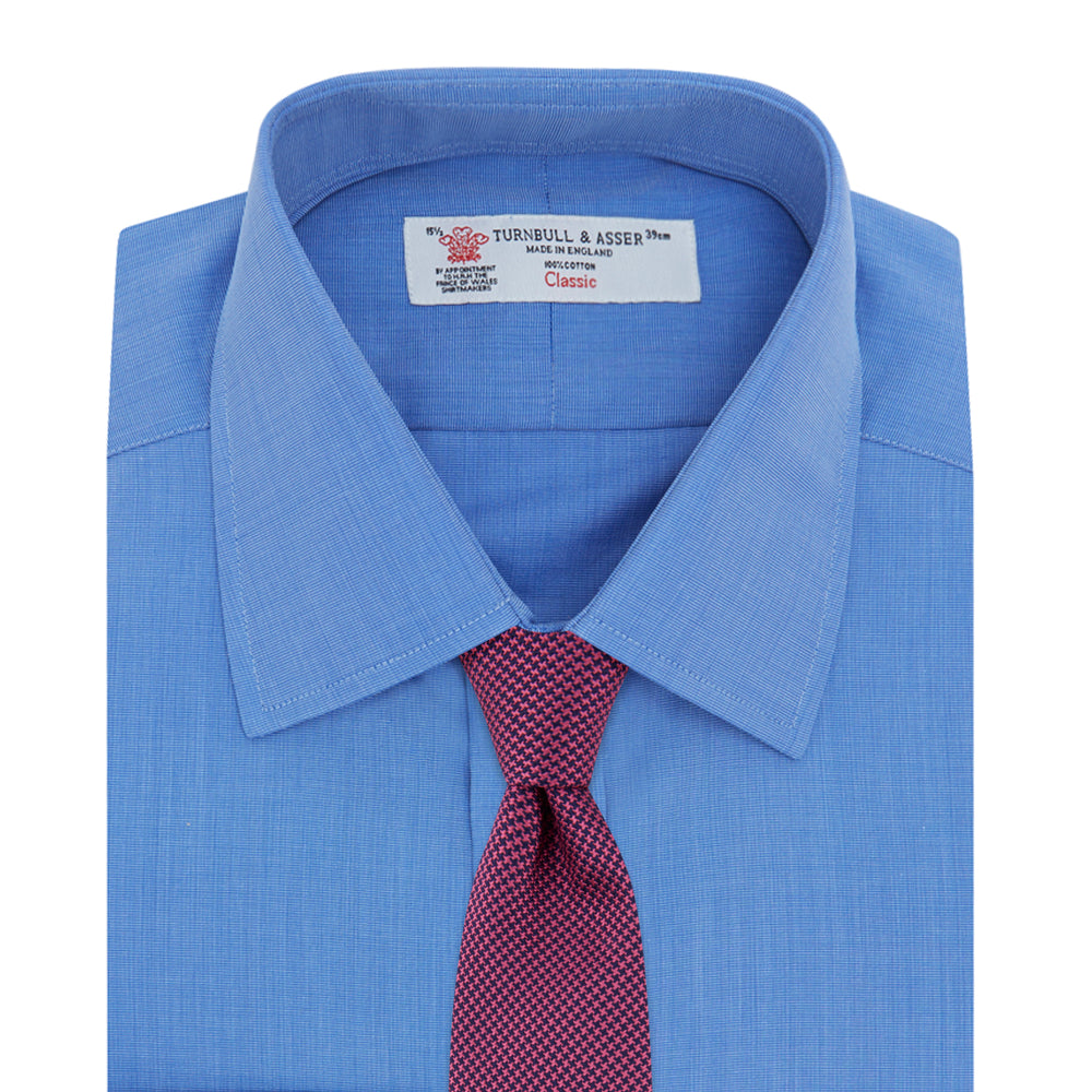 The Turnbull & Asser Dark Blue End-On-End Shirt features a T&A collar and 3-button cuffs, displayed neatly folded on a white background. Ideal for pairing with a navy suit, the label inside the collar is visible.