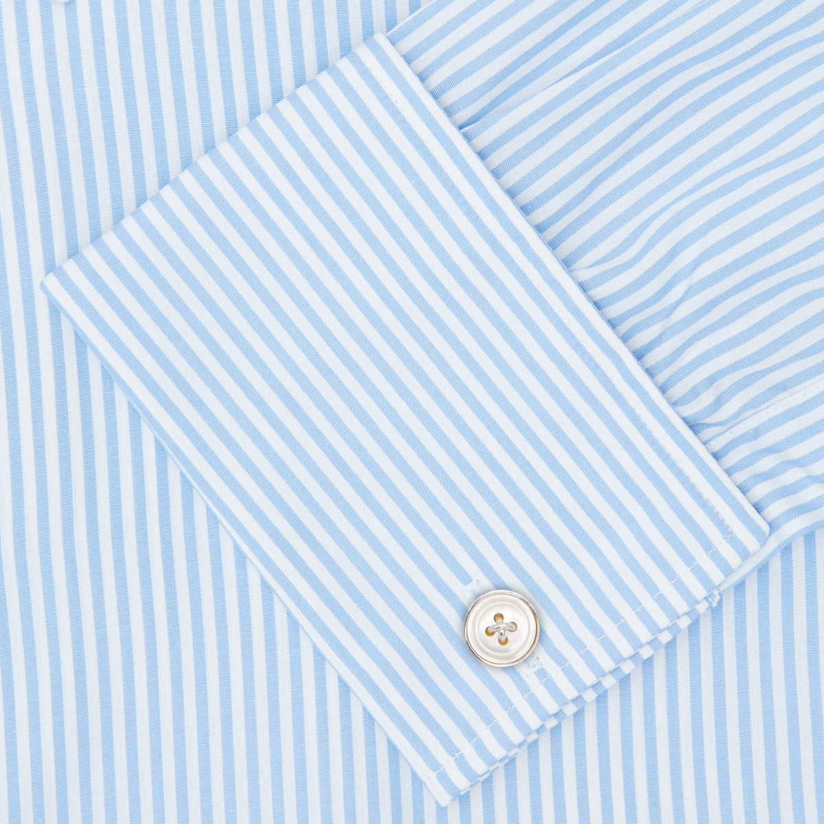 View 6 of product The Turnbull & Asser Light Blue Bengal Stripe Shirt features a T&A collar, double cuffs, and white buttons, offering British flair in blue and white stripes against a plain background.