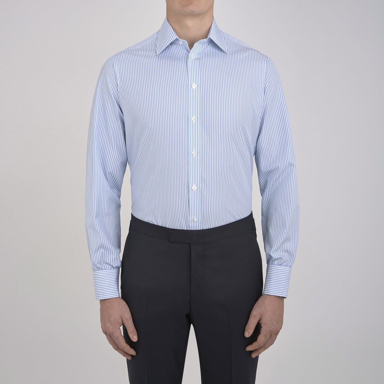 View 2 of product The Turnbull & Asser Light Blue Bengal Stripe Shirt features a T&A collar, double cuffs, and white buttons, offering British flair in blue and white stripes against a plain background.