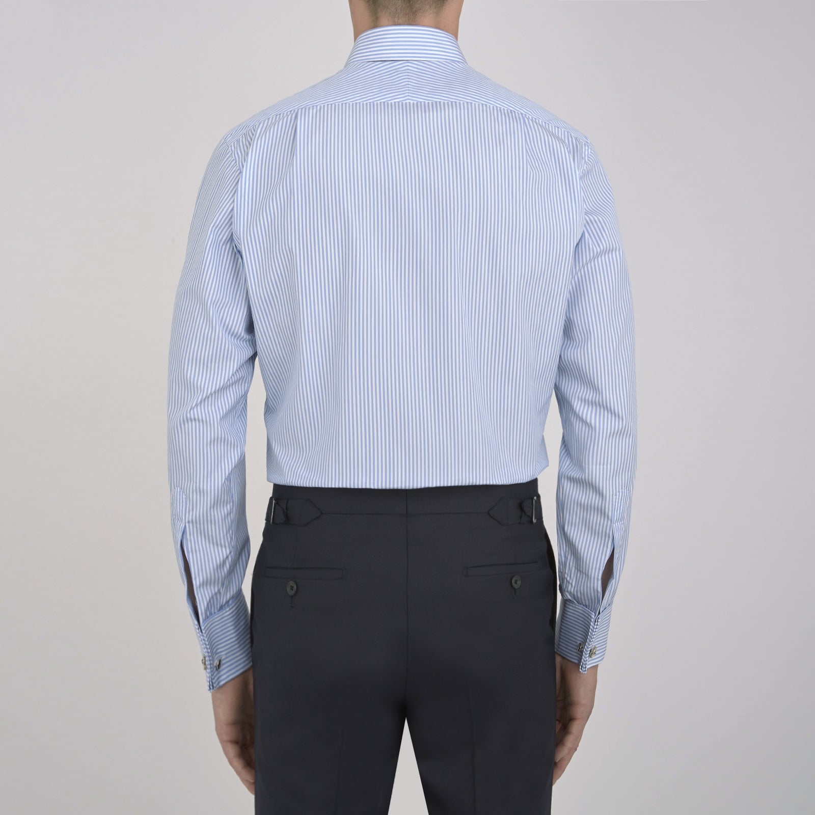 View 3 of product The Turnbull & Asser Light Blue Bengal Stripe Shirt features a T&A collar, double cuffs, and white buttons, offering British flair in blue and white stripes against a plain background.