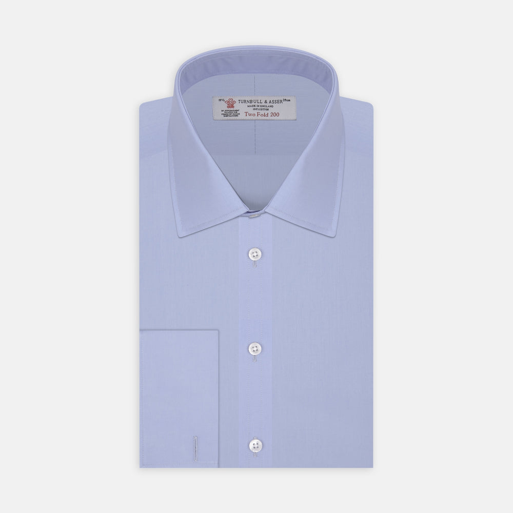 The Turnbull & Asser Two-Fold 200 Blue Cotton Shirt features a T&A collar, double cuffs, white buttons, and a visible label inside the collar, displayed neatly folded on a plain white background for superior breathability.