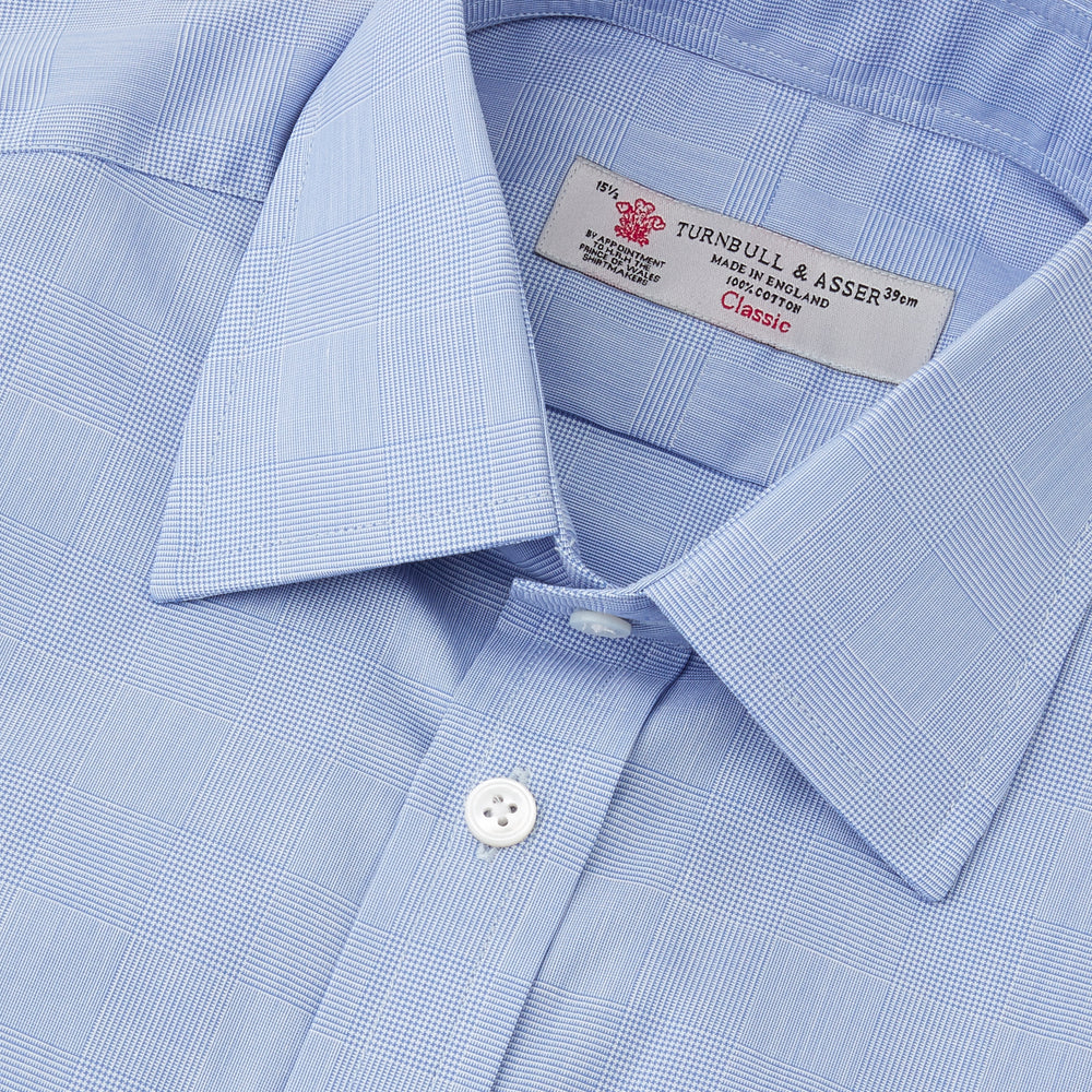 The Turnbull & Asser Blue Prince of Wales Check Shirt features a T&A collar and double cuffs, shown against a white background—ideal for timeless, minimalist style.