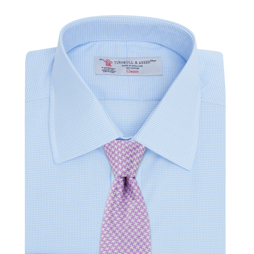 The Sky Blue Micro-Check Cotton Shirt by Turnbull & Asser features a T&A collar and 3-button cuffs, offering a refined take on classic British style. The shirt is neatly folded, showcasing its signature elegance against a white background.