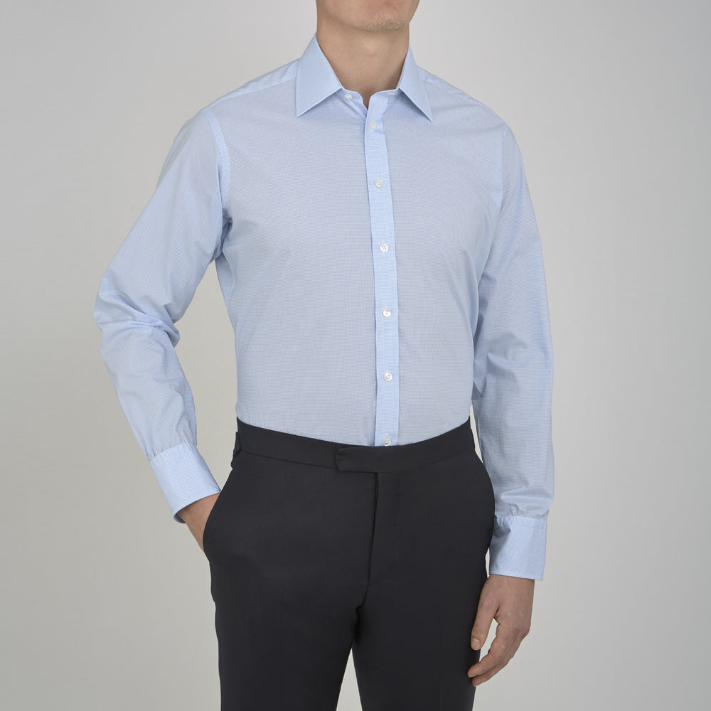 The Sky Blue Micro-Check Cotton Shirt by Turnbull & Asser features a T&A collar and 3-button cuffs, offering a refined take on classic British style. The shirt is neatly folded, showcasing its signature elegance against a white background.