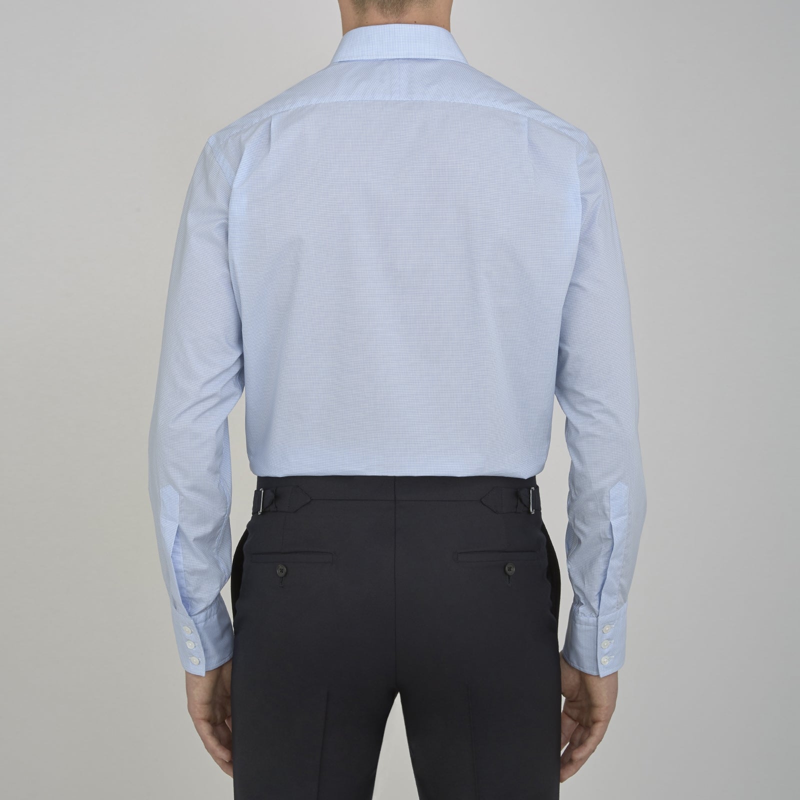View 3 of product The Sky Blue Micro-Check Cotton Shirt by Turnbull & Asser features a T&A collar and 3-button cuffs, offering a refined take on classic British style. The shirt is neatly folded, showcasing its signature elegance against a white background.