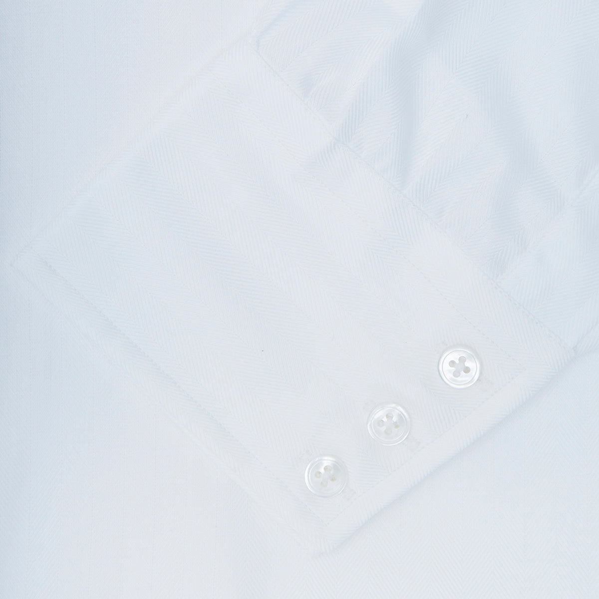 View 6 of product The Turnbull & Asser White Herringbone Superfine Cotton Shirt features a T&A collar and 3-button cuffs, displayed against a light blue background—ideal for minimalist styles or pairing with bold ties.
