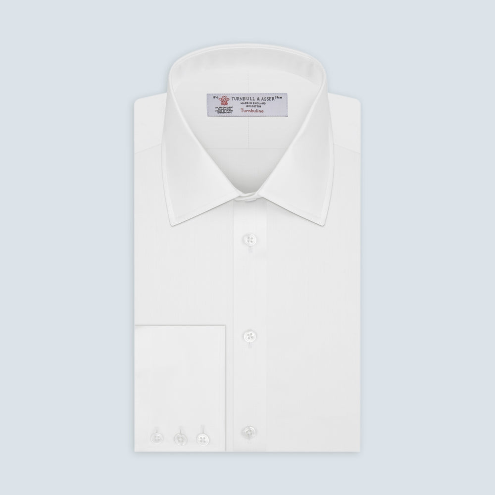 The Turnbull & Asser White Herringbone Superfine Cotton Shirt features a T&A collar and 3-button cuffs, displayed against a light blue background—ideal for minimalist styles or pairing with bold ties.