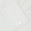 View 6 of product The Turnbull & Asser Cream Herringbone Superfine Cotton Shirt features a T&A collar and 3-button cuffs, ideal for minimalist style or bold ties, shown neatly folded against a plain white background.